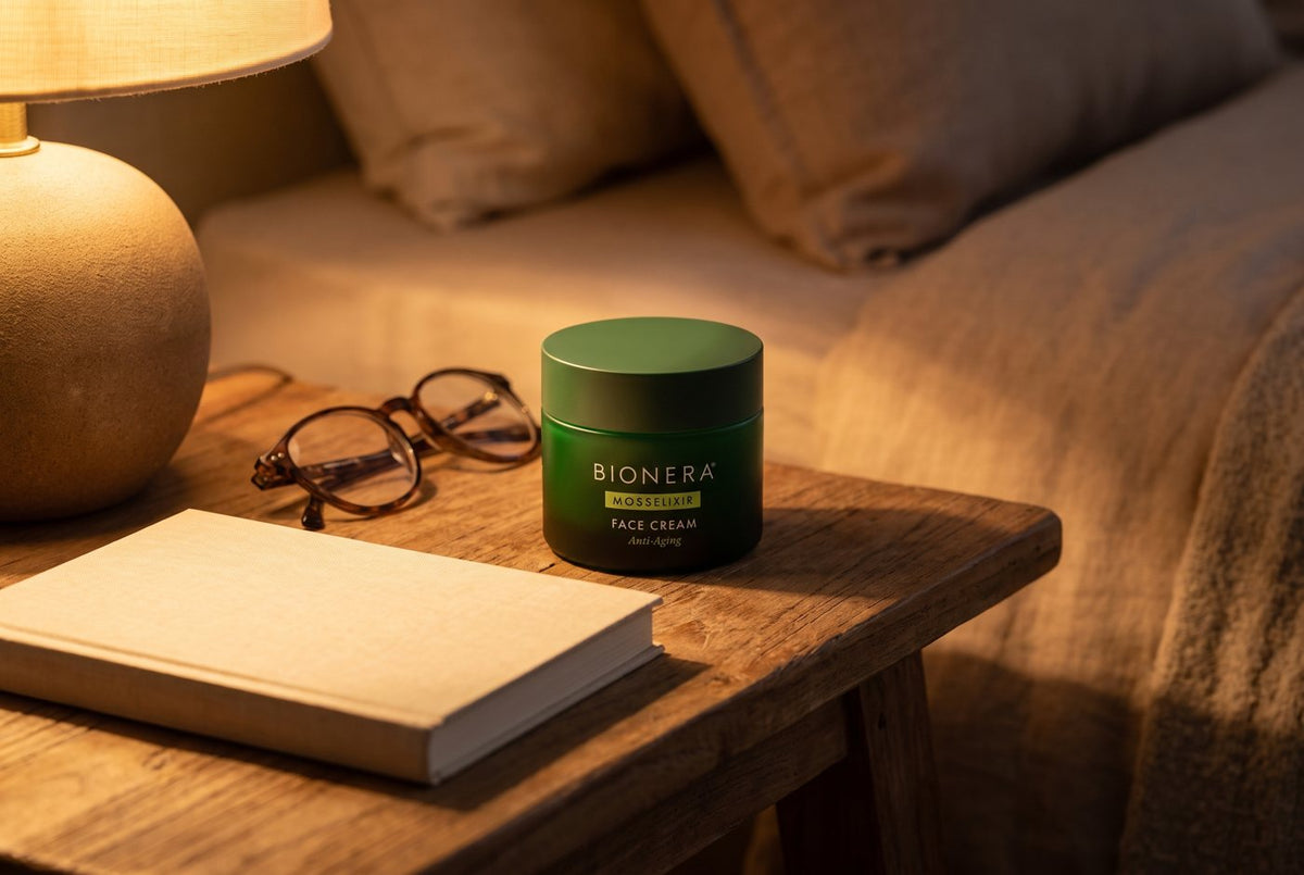 MossElixir Face Cream auf dem Nachttisch neben Lesebrille und Buch